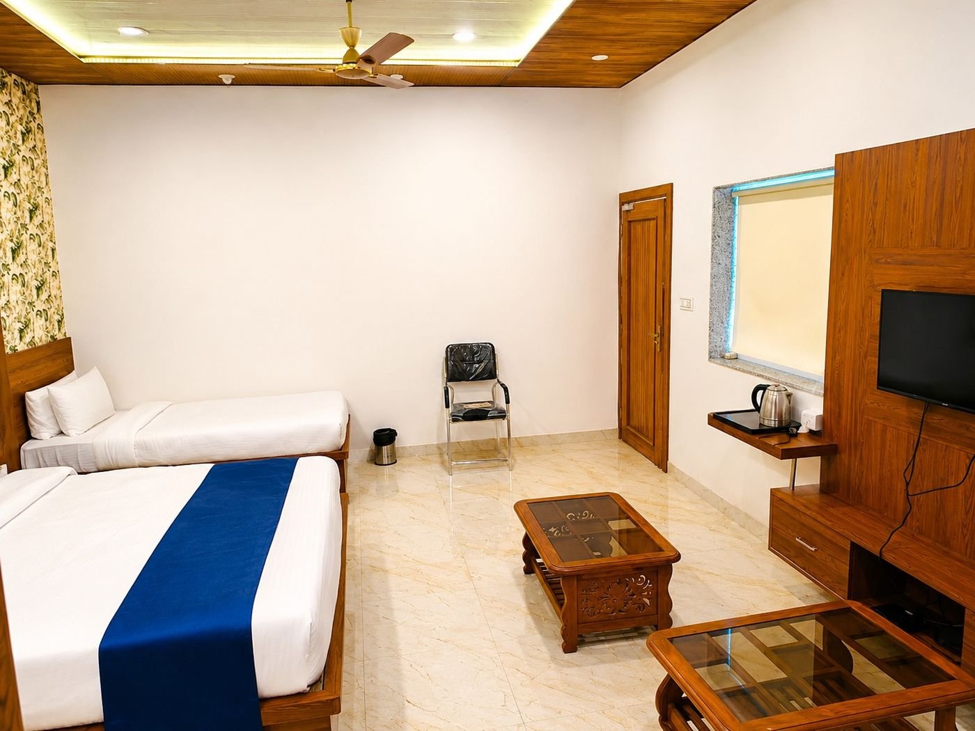 Super deluxe triple-bed room at The Ambay Villa Udaipur with a seating area, coffee table and TV